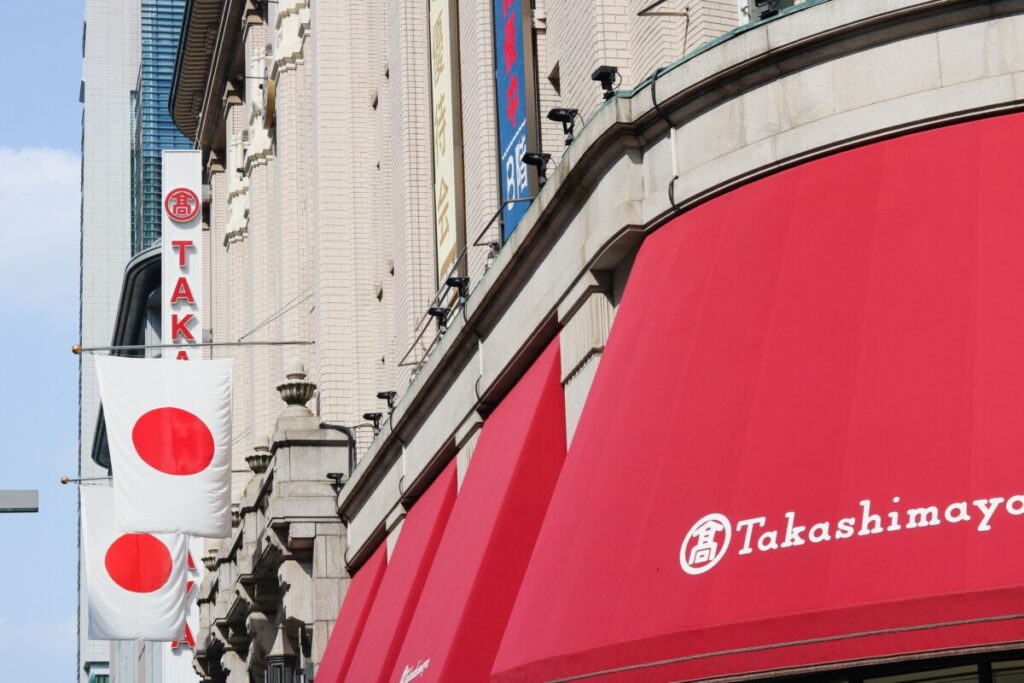 Takashimaya department store in Japan with red signage and Japanese flags offering tax-free shopping for international tourists